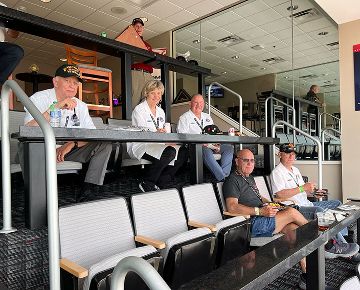 Group of Vietnam veterans enjoying a nascar race from a private booth